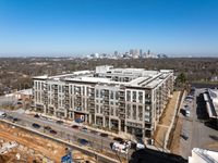 Modern urban apartment complex with a stunning cityscape backdrop, featuring ample balconies and contemporary architecture.