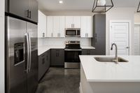 Modern kitchen with sleek stainless steel appliances, elegant cabinetry, quartz countertops, and stylish subway tile backsplash.