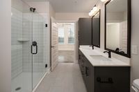 Elegant modern bathroom showcasing double sinks, sleek glass shower, and trendy lighting fixtures.