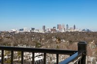 Breathtaking city skyline view from a balcony, showcasing vibrant urban landscape and clear blue skies.