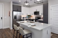 Sleek modern kitchen featuring a center island with elegant bar seating, stainless steel appliances, and minimalist cabinetry.