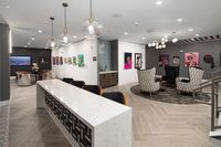 Chic lounge area with stylish seating, contemporary artwork, and elegant lighting in a modern apartment building.