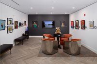 Contemporary art gallery lounge featuring vibrant artwork, cozy seating with plush chairs, and elegant wood flooring.