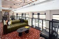 Chic open-concept living area with elegant modern furniture, vibrant decor, and large windows providing natural light.