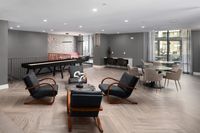 Modern lounge area with elegant seating, accent tables, and sleek floors, perfect for social gatherings or relaxation.