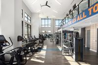 Bright and modern fitness center with state-of-the-art equipment, high ceilings, and large windows for natural light.
