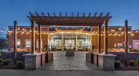 Charming leasing center with inviting string lights, cozy seating areas, and a picturesque pergola.