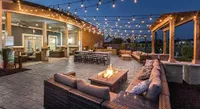 Charming outdoor patio with cozy seating, ambient string lights, and a warm fire pit, perfect for evening gatherings.