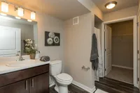 Step into comfort with a spacious bathroom featuring a standing shower, sleek lighting, and a walk-in closet.