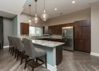Enjoy the spacious, open-concept kitchen at Legacy Landing, complete with abundant cabinet storage and a breakfast bar with seating.