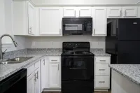 Bright, stylish, and fully equipped — kitchens at The Bristol Apartments feature white cabinetry, appliances, and plenty of counter space for everyday cooking.