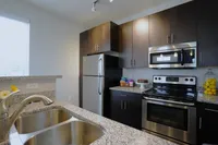 Dark cabinets, granite countertops, and stainless steel shine—this kitchen is equal parts style and function.