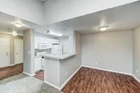 This partially open-concept layout offers a flexible flow between the kitchen, dining area, and living room. While not the most updated kitchen, the apartment is thoughtfully maintained and features a breakfast bar for added functionality.