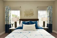 Bright and breezy, this bedroom offers symmetry, sunshine, and serene style—perfectly framed between two large windows.