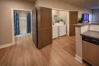 Designed for daily ease: This smart apartment layout reveals a full-size washer and dryer tucked behind sleek doors for a seamless look.