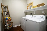 Laundry day made easy with a full-size washer and dryer in every home — no quarters, no waiting. Chic laundry room with modern washer and dryer, stylish storage ladder, and neatly organized shelving for a tidy home.