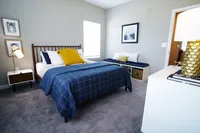 Your retreat, your pace. Spacious primary bedrooms offer the quiet and comfort you crave. Cozy bedroom with stylish decor featuring a comfortable bed, elegant bedside lamp, and inviting window seating.