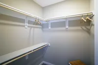 Storage that actually works for you — walk-in closets with built-in shelves and double racks to keep things organized. Spacious walk-in closet featuring ample shelving and clothing racks, perfect for organized living.