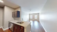 Start in the kitchen, stay for the view. This open layout flows into a sunlit living space that feels as good as it looks. Bright open-concept apartment with a sleek kitchen featuring granite countertops and stainless steel appliances, leading into a sunlit living area with large windows and elegant hardwood floors.