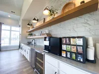 Coffee, cold drinks, and space to unwind. Camden Park is here for your kind of routine. Modern kitchen area with sleek countertops, sophisticated shelving, and a built-in beverage station under warm lighting for an inviting ambiance.