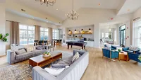 Plenty of space to hang out, shoot a game of pool, or grab a coffee — this clubhouse actually feels like part of your home. Elegant communal lounge with modern chandeliers, plush seating, pool table, and cozy dining area, perfect for relaxation and socializing.
