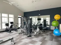 Mirrored walls, full-body equipment, and plenty of space to move freely. No membership required. Modern fitness center with natural light, featuring state-of-the-art exercise machines and vibrant yoga balls.