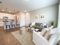 Open-concept living that keeps things connected and easy to navigate. Modern open-concept living room and kitchen with sleek furnishings, stylish countertops, and inviting seating area.