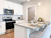 A smart layout with storage, counter space, and flow that works for everyday living. Modern kitchen with sleek stainless steel appliances, elegant granite countertops, and inviting breakfast bar seating.