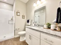 Sleek finishes, a walk-in shower, and plenty of counter space to start or end your day. Modern bathroom with elegant granite countertop, stylish under-sink cabinetry, and a sleek glass-enclosed shower.