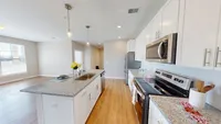 A kitchen that works hard and looks good, with granite countertops and stainless steel everything. Modern apartment kitchen with sleek granite countertops, stainless steel appliances, and bright natural lighting.