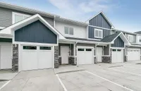 Charming townhouse exterior with modern design, featuring elegant blue and white paneling and spacious garage.