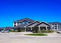 Modern apartment complex featuring multi-story buildings with stylish architecture, surrounded by lush landscaping and ample parking.