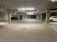 Spacious underground parking garage featuring well-lit spaces, secure environment, and convenient access for residents.