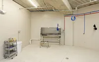 Modern utility room with sleek stainless steel sink, bright lighting, and organized storage shelves, ideal for multi-purpose use.