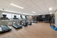 Modern fitness center with treadmills, exercise bikes, and vibrant natural lighting, perfect for energizing workouts.