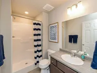 Modern bathroom with sleek vanity, stylish mirror, and elegant shower area, perfect for comfort and relaxation.