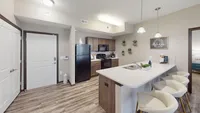 Kitchens include wood-style flooring, a dishwasher, microwave, and a large amount of counterspace.