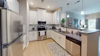Enjoy cooking in style with stainless steel appliances, bright white cabinets, and plenty of prep space in this modern kitchen.