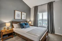 Large windows with natural light, vaulted ceilings, and lush carpeting are bedroom features available at Kinsley Forest Apartments.