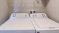 Modern laundry room featuring a sleek washer and dryer set with convenient shelving for storage.