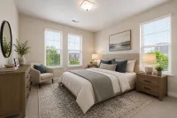 Primary bedroom with plush carpeting, large windows, and ample natural light.