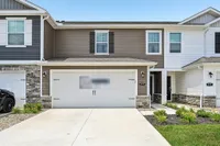 Charming townhouse with a modern facade, featuring a double garage and well-maintained front garden.