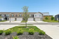 Charming suburban townhouse complex with beautiful landscaping and spacious driveways, ideal for modern family living.