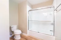 Spacious bathroom with pristine glass sliding door