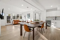Modern open-concept apartment with a cozy living area, stylish dining space, and sleek kitchen featuring elegant cabinetry and natural light.
