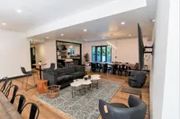 Contemporary open-concept living and dining area with stylish furnishings, large windows, and ambient lighting.
