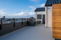 Spacious rooftop terrace with sleek railing and vibrant sky views, perfect for entertaining and relaxation.