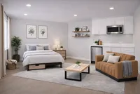 Modern studio apartment with cozy bed, stylish sofa, and sleek kitchenette. Bright and welcoming with elegant decor and ample lighting.