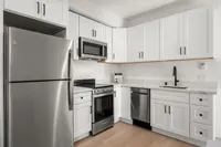 Modern kitchen with sleek stainless steel appliances, elegant white cabinetry, and chic marble countertops.
