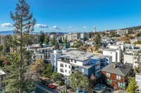 Vibrant urban landscape with modern apartment buildings and scenic views of the city skyline under a clear blue sky.